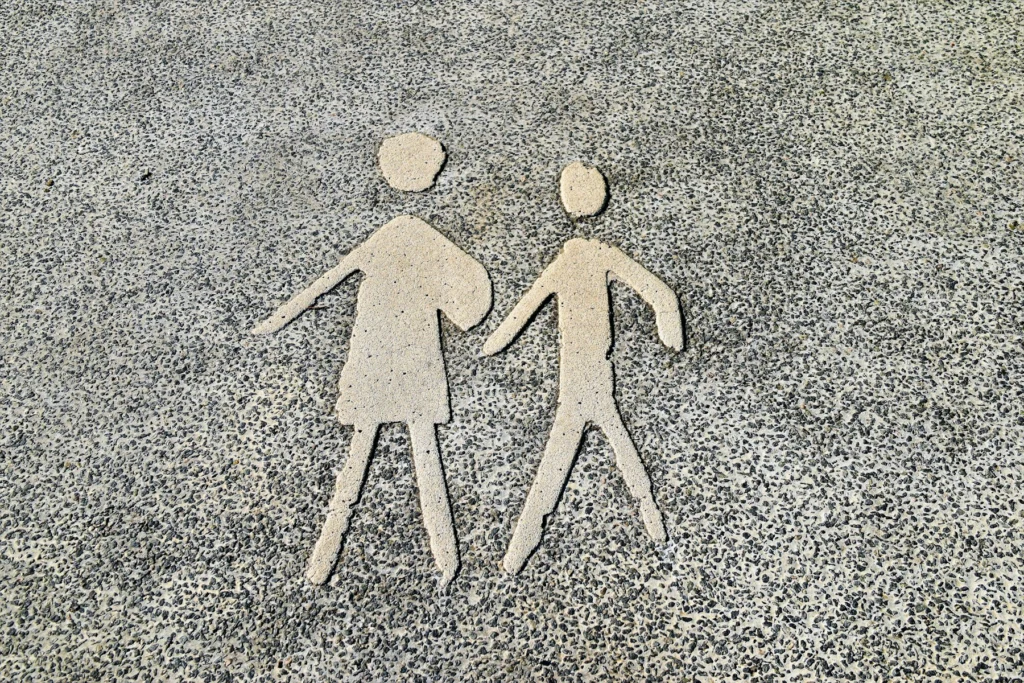 Duas figuras de papel lado a lado sobre o chão de cascalho